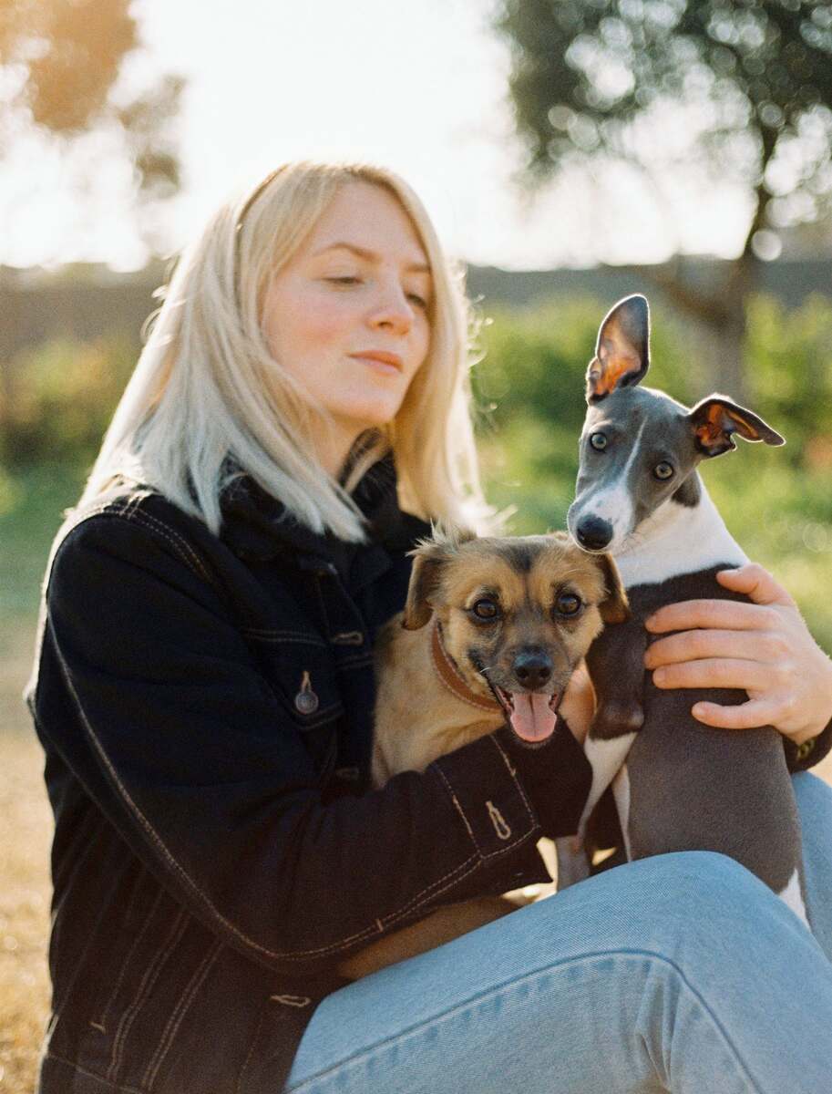 Personne assise en extérieur avec deux chiens
